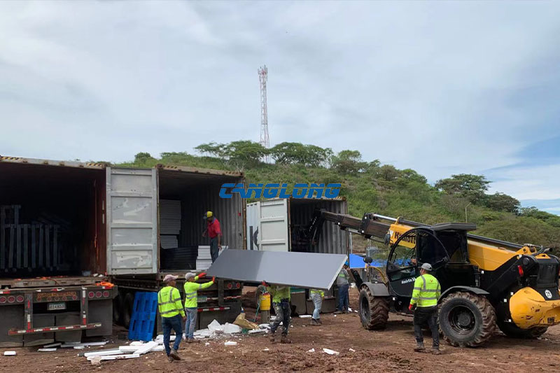Workers unloading EPS sandwich panels at Panama steel warehouse construction site