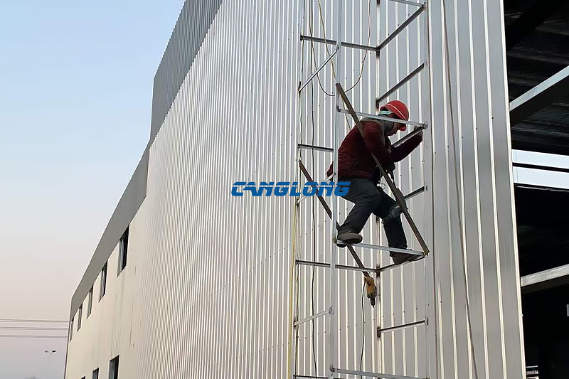 Worker fixing wall panels to the steel girts at the industrial plant in Skopje, North Macedonia