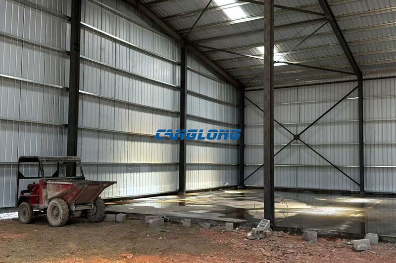 Interior of the Zambia warehouse showing the centre column row, metal wall sheets and cross-bracing