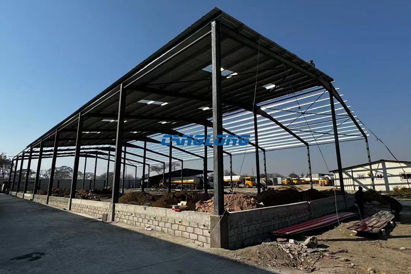 Steel roof and translucent skylight sheets being installed over the Zambia warehouse frame