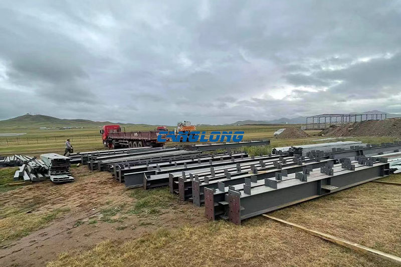 Steel structure components being unloaded from a container at a mining workshop site in Ulaanbaatar, Mongolia