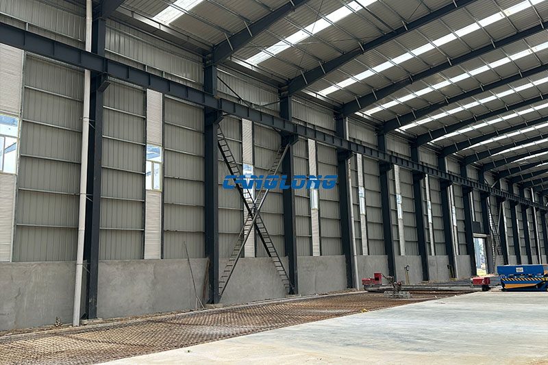 Inner face of the Bangkok plant side wall — 4.2 m brick base, 900-type coated corrugated sheet above, X cross bracing and eave gutter visible